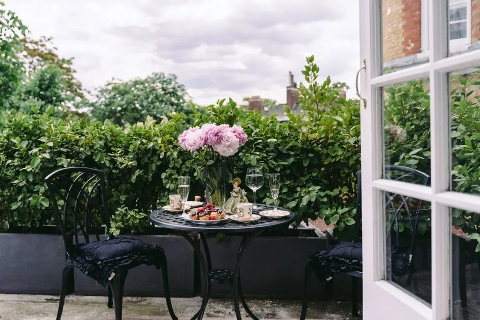 Patio en ville, pivoines blanches et hortensias, table en metal.